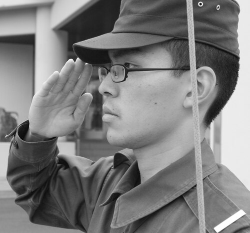 A member of the Japanese Maritime Self Defense Force salutes the flag as it makes its journey up the pole during morning colors. The United States and Japanese colors are raised every day at 8 a.m. and are lowered at sunset.