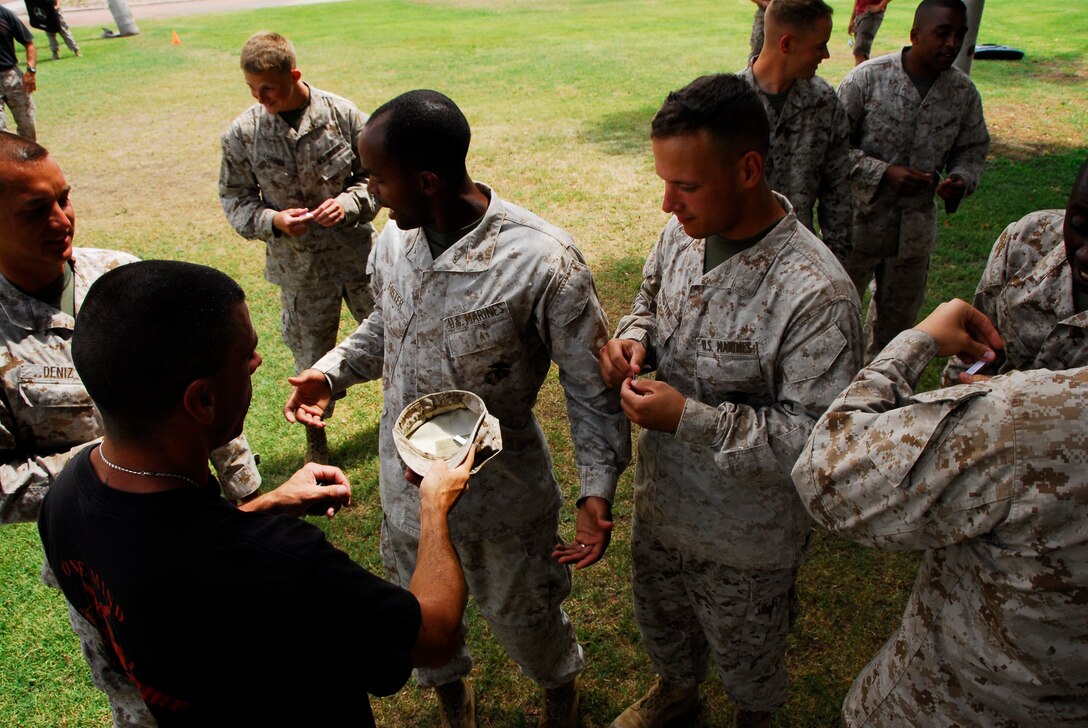 Marines in the current martial arts instructor course at Marine Corps Air Station Yuma, Ariz., pull numbers May 21, 2009 to see what order they will be sprayed with Oleoresin Capsicum, a nonlethal weapon used by law enforcement. While the spray is not a mandatory part of the curriculum, the 15 students in the class volunteered to get sprayed and receive a special certification. (Photo by Cpl. Laura A. Mapes)