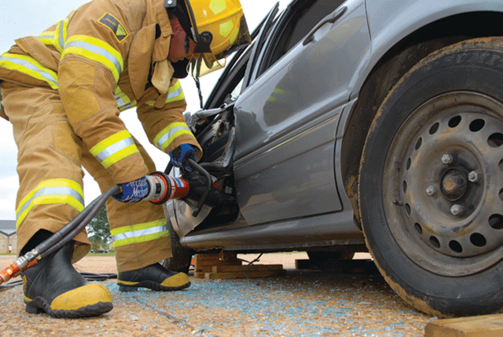 A Maxwell-Gunter firefighter uses the "jaws-of-life" tool to open a car door during a simulated automobile accident at Gunter. The accident was part of the base's May HURICON exercise that involved preparation for bad weather and evacuees from a gulf-coast hurricane. (U.S. Air Force photo/Jamie Pitcher)
