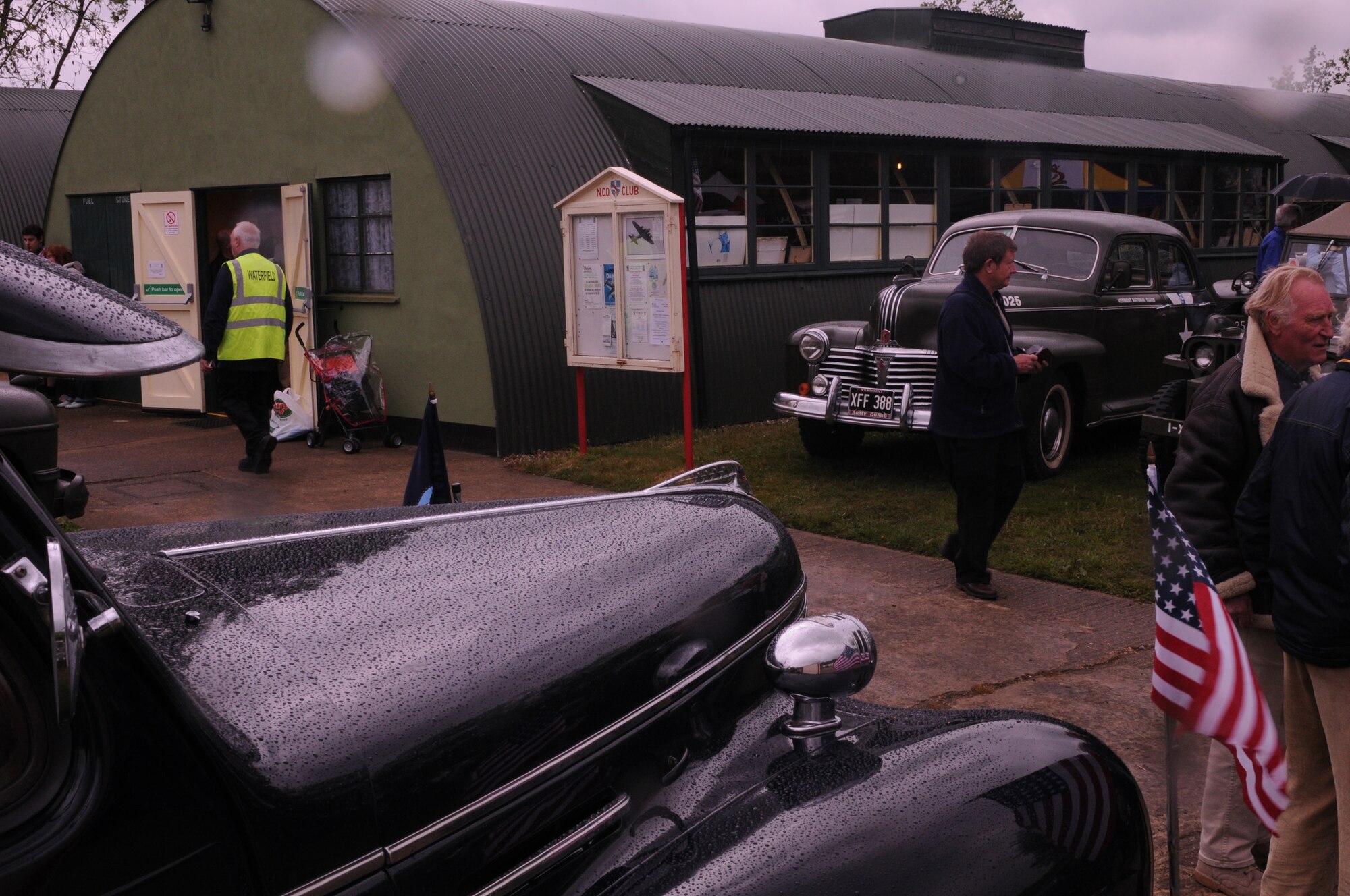 Visitors walk around the Red Feather Club and World War II era vehicles during the annual grand opening of Royal Air Force Horham May 17. The Red Feather Club was the former 95th Bombardment Group NCO Club during the war and has been fully restored by the 95th Bombardment Group Heritage Association, a British organization. (U.S. Air Force photo by Staff Sgt. Nathan Gallahan)