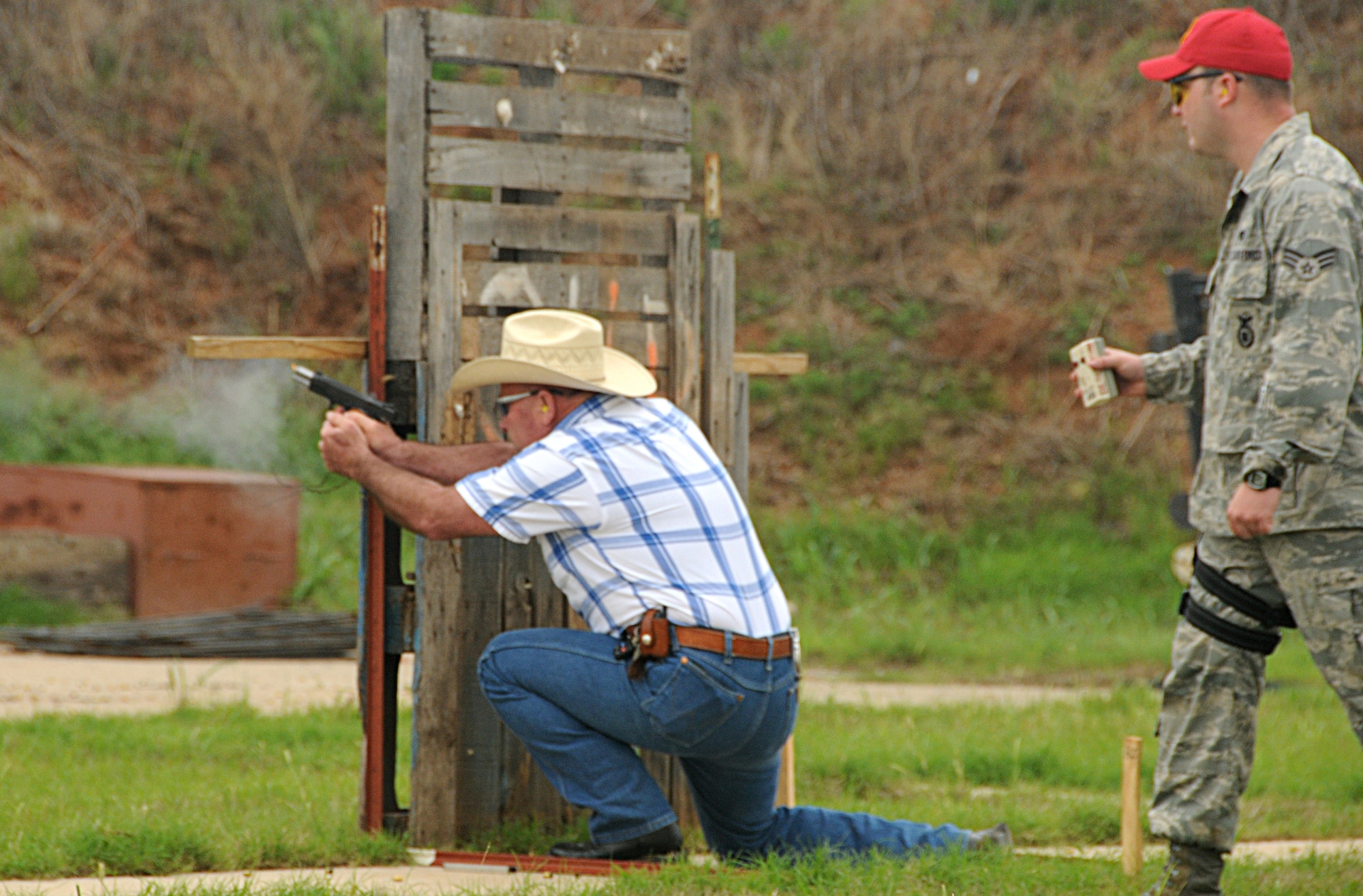 ALTUS AIR FORCE BASE, Okla --- Sherriff Roger LeVick, from the Jackson County Sherriff’s Office, fires a Colt 1911 (45 Caliber) pistol at the “Shoot-Out” competition at the Altus Police Department Firing Range, in support of police week, on May 14. Sherriff LeVick is timed by Senior Airman Rayce Schneider, from the 97th Security Forces Squadron, and finished among the top five scores by completing the target course in 85.52 seconds. (U.S. Air Force photo by Senior Airman Cherice Bryant)
