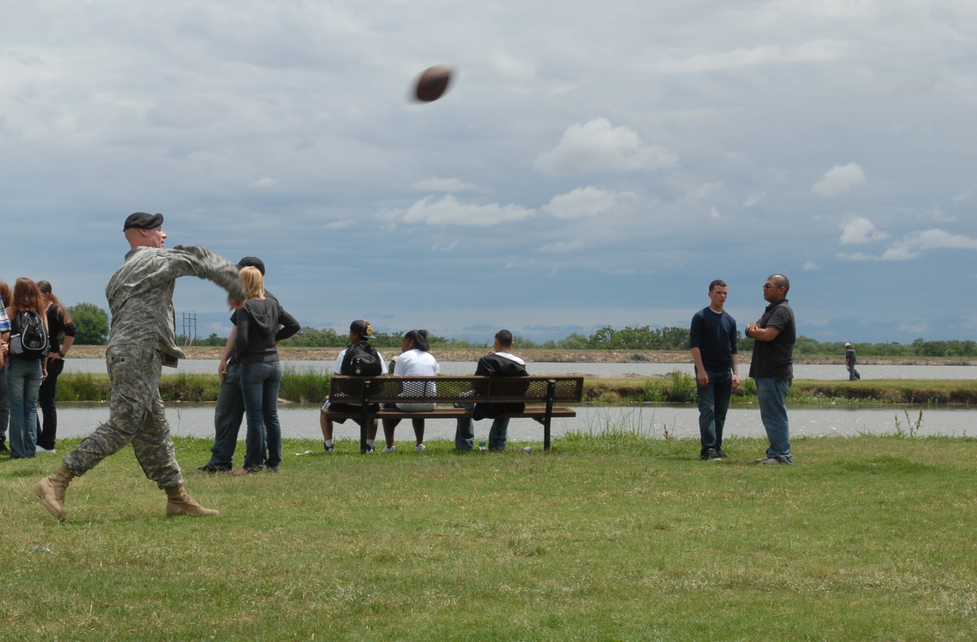 A Soldier and other picnic attendees engage in a game of football at the picnic. (U.S. Air Force photo by Airman Clayton Lenhardt)