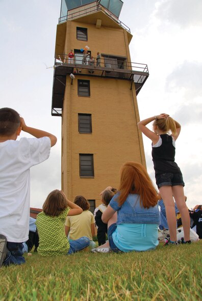 Staff Sgt. Christopher Grisingher, 42nd Operations Support Flight, tosses a packaged egg from Maxwell's aircraft control tower to Maxwell Elementary School students waiting below. (U.S. Air Force photo/Jamie Pitcher)