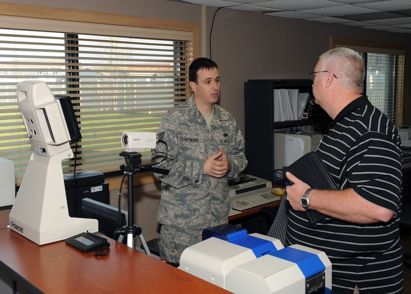 MINOT AIR FORCE BASE, ND -- Tech. Sgt. Richard Ditmars, non commissioned officer in charge of the 5th Security Forces Squadron Pass and Registration office, explains the different policies and procedures governing the pass and registration office to an Air Combat Command Inspector General team member during the Nuclear Surety Inspection here May 18. An NSI is designed to evaluate a unit's readiness to execute nuclear operations. Areas to be evaluated during the NSI include operations, maintenance, security, and support activities needed to ensure the wing performs its mission in a safe, secure and reliable manner. This no-notice inspection concluded May 22. (U.S. Air Force photo by Staff Sgt. Keith Ballard)