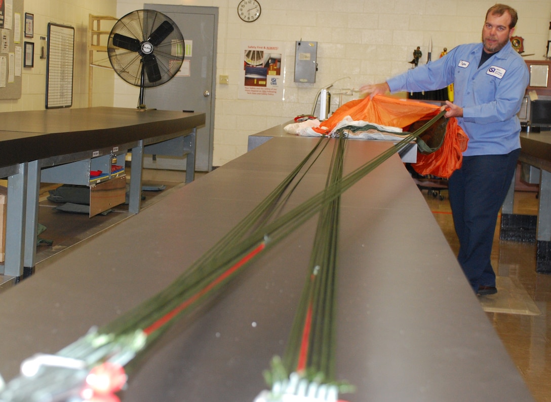 Mark Burroughs, a Lier Siegler, Inc. contractor with the 80th Flying Training Wing, prepares to repack a parachute in the fabrication shop of the Aircrew Flight Equipment. (U.S. Air Force photo/ Airman 1st Class Valerie Hosea)