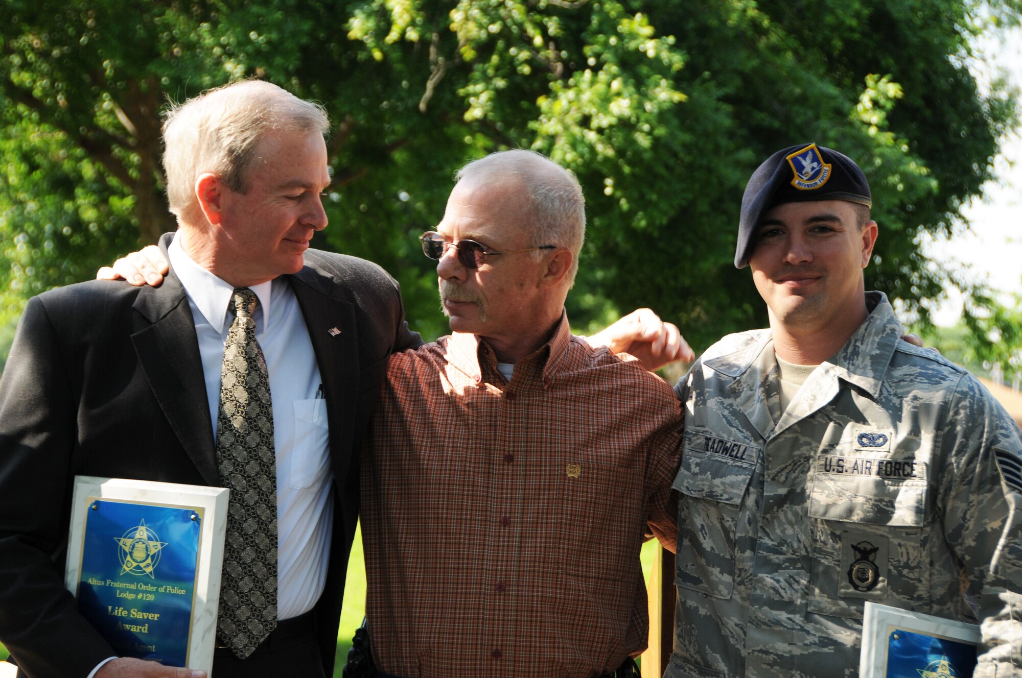 ALTUS AIR FORCE BASE, Okla. – Special Agent Ross Bergstresser (L), of Office of Special Investigations and Staff Sgt. Matt Treadwell (R), of 97 Security Forces Squadron hug Deputy Kevin Walker (M) at the Police Award ceremony. Deputy Walker had a heart attack on May 14, 2009 at the firing range; this took place during a competition between Altus Police Department, Altus AFB SFS, and OSI. These two heroes saved Deputy Walker’s life, and kept him alive until emergency medical attention arrived, for this they received the Fraternal Order of Police Life Saver Award. (U.S. Air Force Photo/Senior Airman Marianne E. Lane)