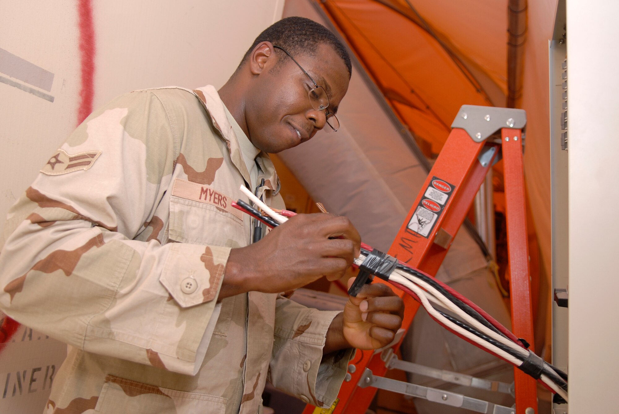 Airman 1st Class Brandon Myers, a 379th Expeditionary Civil Engineer Squadron electrical systems apprentice, bundles electrical wiring in the civil engineer compound in preparation for bringing the new gas-fired turbine power plant online, May 21, 2009, at an undisclosed location in Southwest Asia.  The power plant will save millions of dollars annually and help transform the base from expeditionary to enduring.  Airman Myers hails from Huntington, W. Va. and is deployed from Travis Air Force Base, Calif. in support of Operations Iraqi and Enduring Freedom and Combined Joint Task Force - Horn of Africa.  (U.S. Air Force photo/Senior Airman Andrew Satran/released)