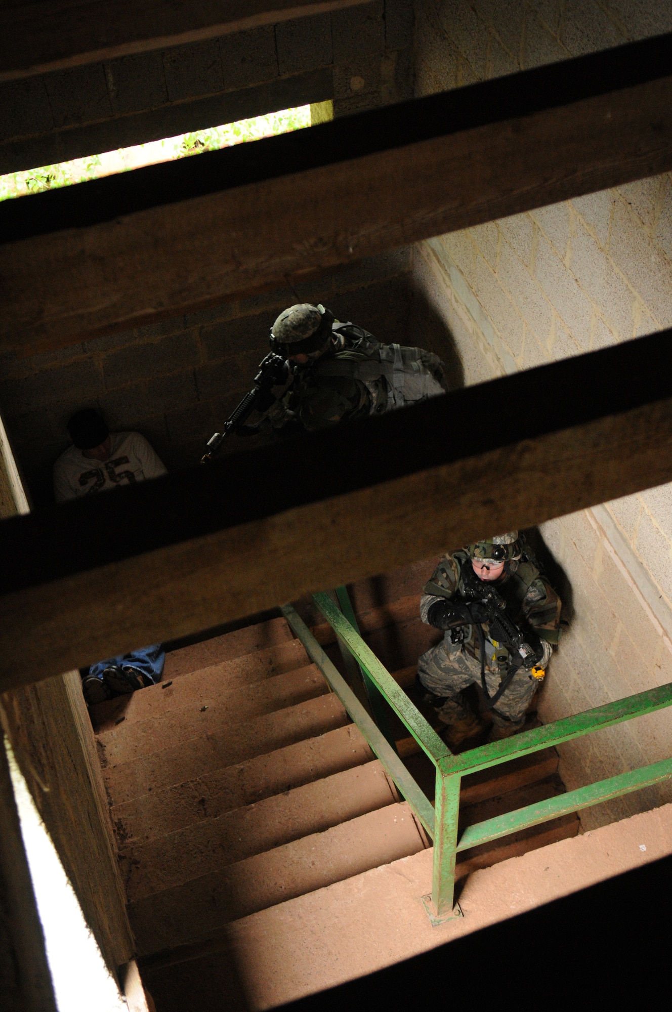 United States Air Force Staff Sgt. Joshua Dickinson, 436th Security Forces Squadron, Dover Air Force Base, Delaware, covers the top of a stair case while a squad member advances, Baumholder Germany, May 15, 2009. Sergeant Dickinson is a student at the Creek Defender Regional Training Center, whose mission is to hone and sharpen skills learned through previous training to prepare students for upcoming deployments. (U.S. Air Force photo by Senior Airman Levi Riendeau)
