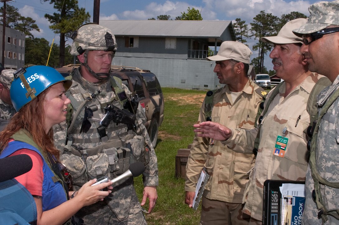 U.S. Army Lt. Col. Trevor Bredenkamp listens to role players as a reporter interviews an Iraqi general regarding the opening of a new police station in the fictitious Iraqi town of Suliyah as part of the brigade’s training at the Joint Readiness Training Center, Fort Polk, La., May 15, 2009. Bredenkamp is the commander of the 82nd Airborne Division's 2nd Battalion, 504th Parachute Infantry Regiment, 1st Brigade Combat Team.