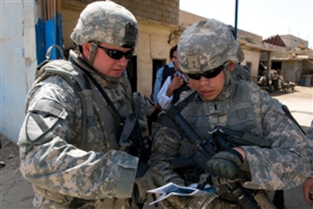 U.S. Army Sgt. 1st Class Robert Hoff (left), a cavalry scout, and 1st Lt. Jacob Lopez (right) attached to Crazy horse Troop, 4th Squadron, 9th Cavalry Regiment, 2nd Heavy Brigade Combat Team, 1st Cavalry Division look at their map during a recent combined reconnaissance patrol with counterparts of the Iraqi Police in the industrial sector of the town of Taza, in Kirkuk, Iraq, on May 16, 2009.