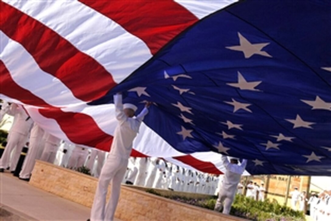 U.S. Navy sailors open an American flag before a Naval Support Activity Memorial Day event, 
Souda Bay, Greece, May 22, 2009. The day's activities included a personnel inspection, Memorial Day ceremony, and a command photo.