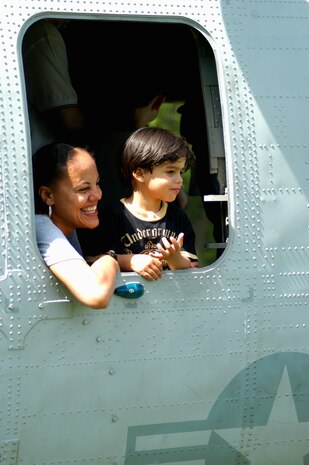 A woman and child peer out of the side window on a CH-46 Sea Knight helicopter after a helicopter raid demonstration by Special Purpose Marine Air Ground Task Force New York. (Official Marine Corps photo by Lance Cpl. Jad Sleiman)