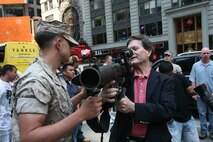 A Marine from Special Purpose Marine Air Ground Task Force New York,  lets a visitor to Marine Day handle his Shoulder-launched Multipurpose Assault Weapon (SMAW). The weapon is an unguided rocket system capable of hitting a tank-sized target 500 meters away. (Official Marine Corps photo by Sgt. Steve Cushman)