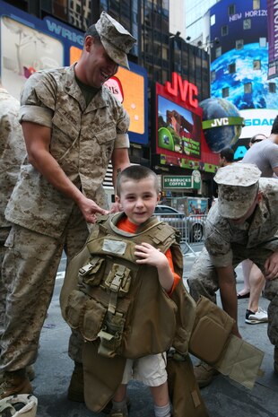 A boy tries on the Marine Corps' flak vest at Marine Day in Times Square. Marines from Special Purpose Marine Air Ground Task Force New York displayed weapons, equipment and their hand-to-hand fighting techniques at the all-day event. (Official Marine Corps photo by Sgt. Steve Cushman)