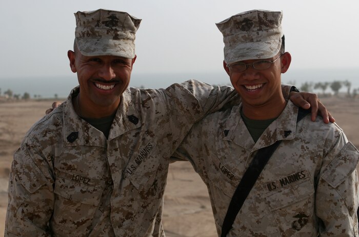 Master Sgt. Juan Lopez, the operations chief, for the 1st Battalion, 8th Marine Regiment Security Detachment,stands with his son, Cpl. Jared P. Lopez, a data/wire technician with Communications Company, 2nd Marine Logistics Group (Forward), aboard Camp Al Taqaddum, Iraq, May 23, 2009. The two Marines found themselves serving side-by-side when both their units deployed to Camp Al Taqaddum in early 2009.