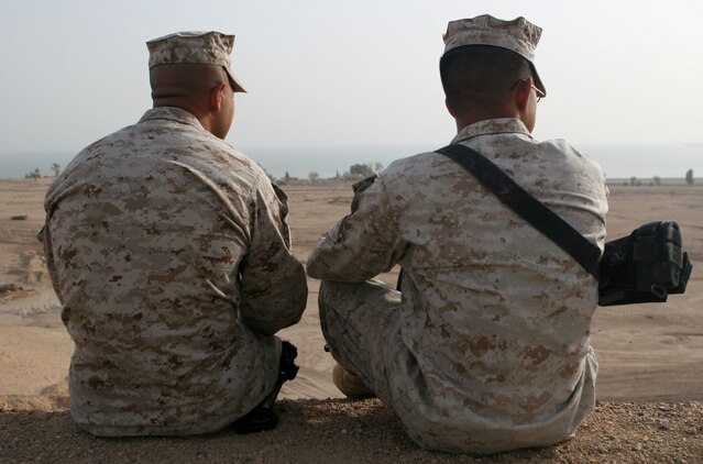 Master Sgt. Juan Lopez (left), the operations chief, for the 1st Battalion, 8th Marine Regiment Security Detachment, sits with his son, Cpl. Jared P. Lopez, a data/wire technician with Communications Company, 2nd Marine Logistics Group (Forward), aboard Camp Al Taqaddum, Iraq, May 23, 2009. The two Marines found themselves serving side-by-side when both their units deployed to Camp Al Taqaddum in early 2009.