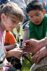 Under the watchful eye of a Marine from 2nd Battalion, 6th Marine Regiment with Special Purpose Marine Air Ground Task Force New York, led by 24th Marine Expeditionary Unit, children look at different Marine Corps weapons following a simulated raid of Clove Lakes Park in Staten Island, N.Y.,  May 23. The event allowed area residents to walk through helicopters and view static displays of weapons. The 24th MEU has more than 900 Marines who are slated to showcase several events for New York's Fleet Week 2009. (Official Marine Corps photo by: Cpl. Patrick Fleischman)