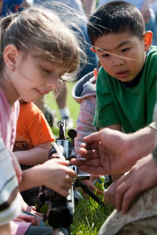 Under the watchful eye of a Marine from 2nd Battalion, 6th Marine Regiment with Special Purpose Marine Air Ground Task Force New York, led by 24th Marine Expeditionary Unit, children look at different Marine Corps weapons following a simulated raid of Clove Lakes Park in Staten Island, N.Y.,  May 23. The event allowed area residents to walk through helicopters and view static displays of weapons. The 24th MEU has more than 900 Marines who are slated to showcase several events for New York's Fleet Week 2009. (Official Marine Corps photo by: Cpl. Patrick Fleischman)