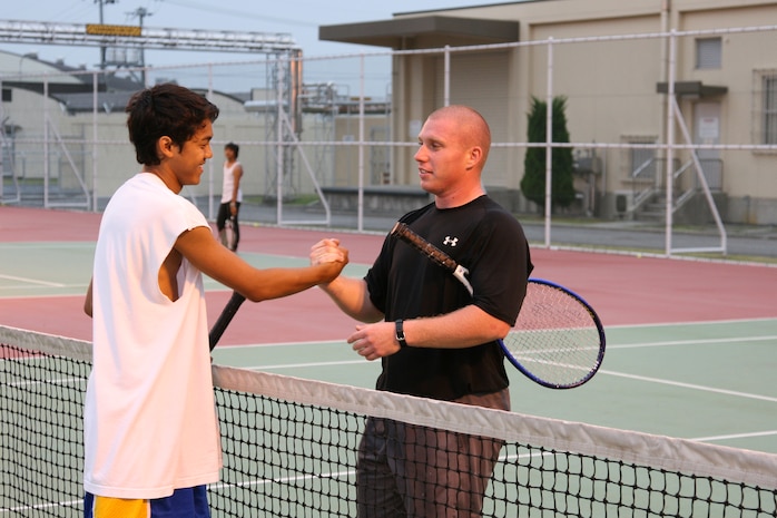 Andre Bugawan (left) shakes Paul Roger's (right) hand after the championship match held Saturday at the station's tennis courts here. The championship match was one pro set in which Roger beat Bugawan 8-6. It was the second time Bugawan fell to Roger Saturday causing Bugawan to be eliminated from the tournament and allowing Roger to take the title.