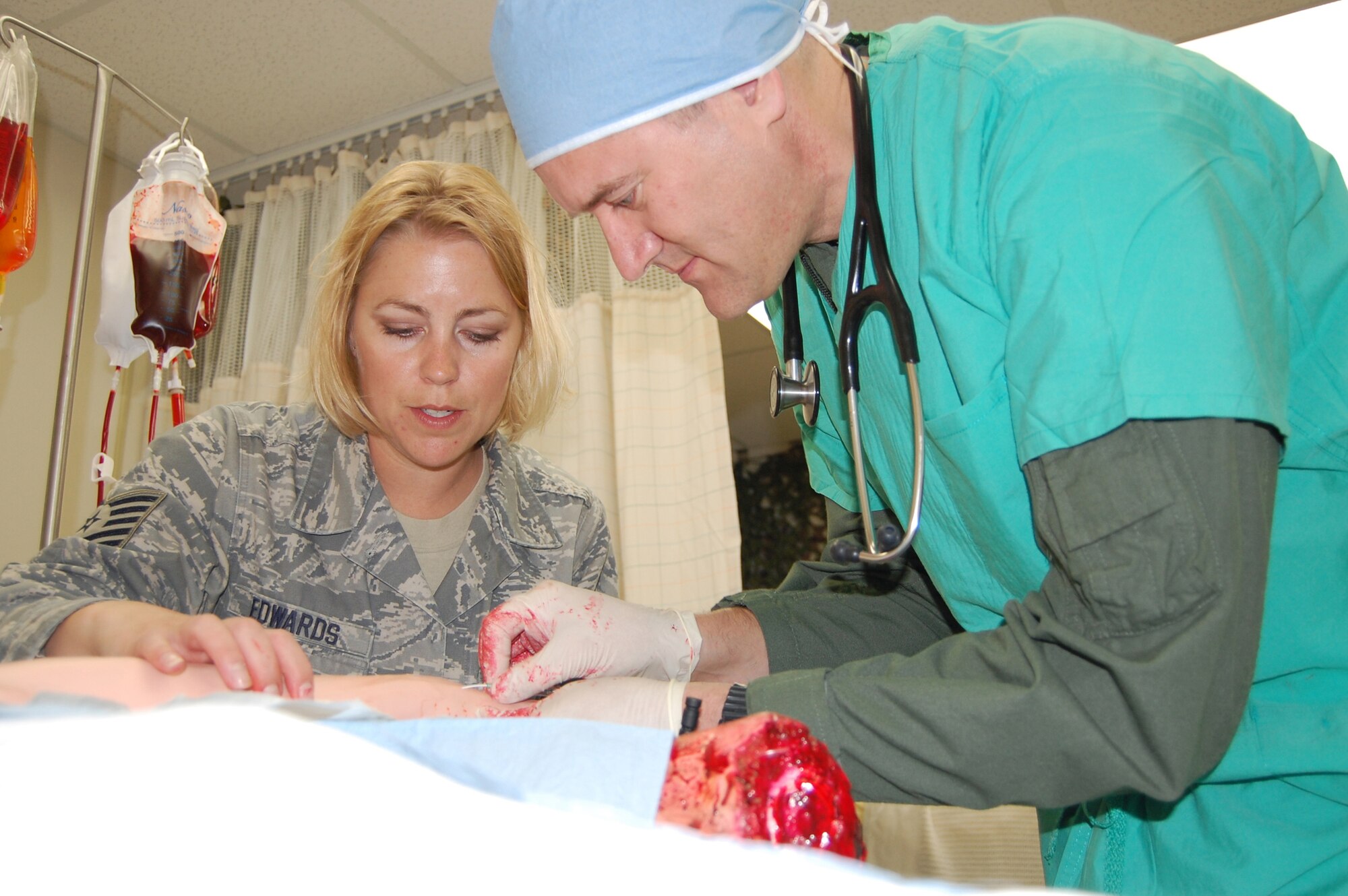 Tech. Sgt. Sarah Edwards, NCOIC of Education and Training at the Malmstrom Clinic, teaches Col. Paul Gydesen, 341st Missile Wing vice commander, how to insert an intravenous needle on a Meti ECS May 14. The vice commander was making his bi-weekly "Out and About with the Troops" visit. (U.S. Air Force photo/Valerie Mullett)