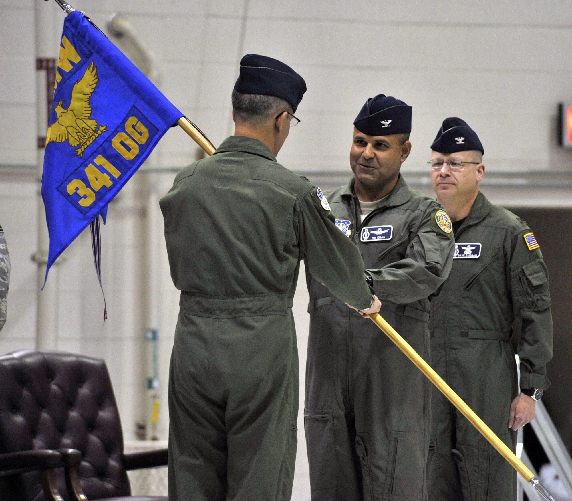 Col. Mohammed Khan, Jr. accepts command of the 341st Operations Group from Col. Michael Fortney, 341st Missile Wing commander, during a change of command ceremony May 20 in the 3-Bay Hangar. Outgoing 341st OG commander Col. David Durgan looks on. (U.S. Air Force photo/John Turner).  