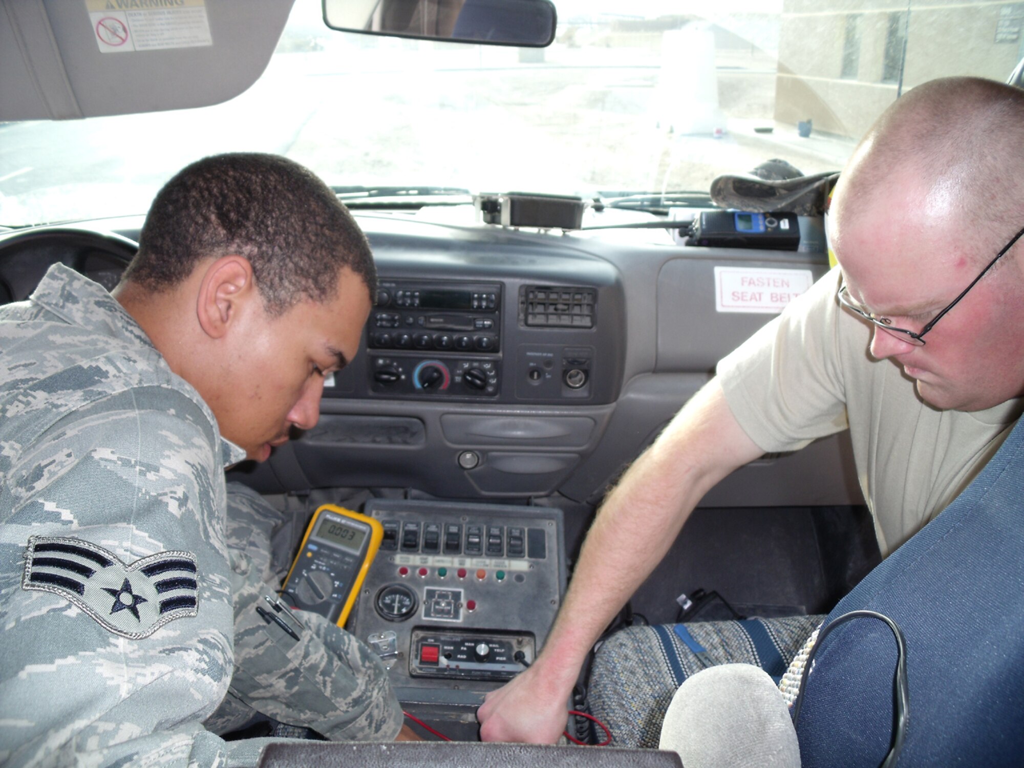 SEYMOUR JOHNSON AIR FORCE BASE, N.C. -- Senior Airman Christopher Twitty (left) and Senior Airman Stephen Roshong install a mobile radio inside an ambulance while deployed to Al Udeid Air Base, Qatar. Airman Twitty is a radio maintenance specialist with the 916th Air Refueling Wing, Air Force Reserve and Airman Roshong is a member of the 4th Fighter Wing Communication Squadron.
