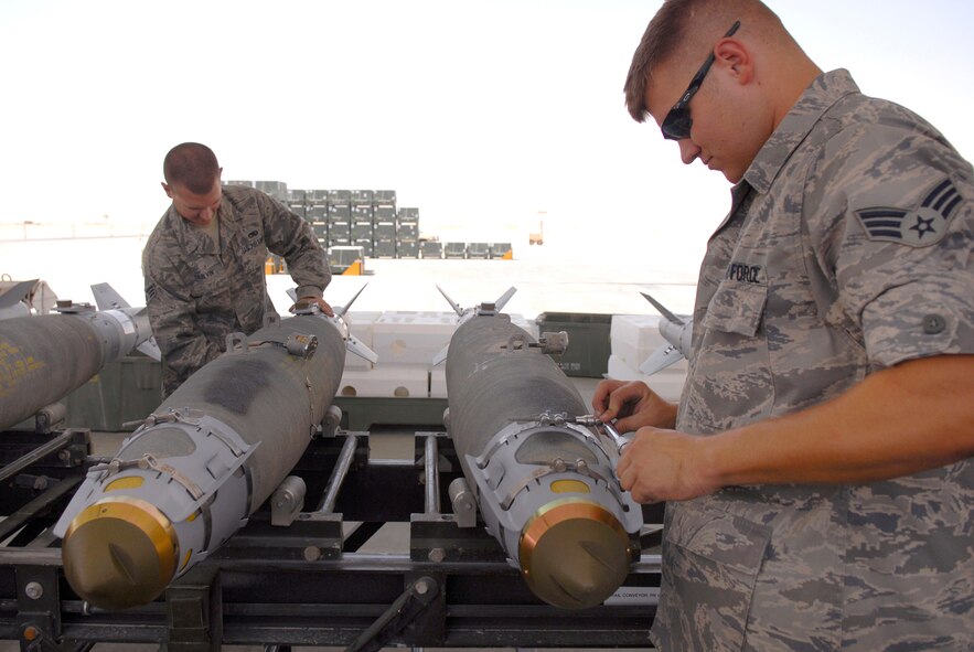 Senior Airman Richard Parvin and Senior Airman Timothy Bradford, 379th Expeditionary Maintenance Squadron munitions systems journeymen, attach KMU-572 fin kits to GBU-38 Version 1 bombs, May 22, 2009, at an undisclosed location in Southwest Asia.  The GBU-38s are assembled and constructed by the base's munitions unit for delivery by B-1B Lancers.  Airman Parvin hails from Birmingham, Ala.  Airman Bradford hails from Burleson, Texas.  Both are deployed from Dyess Air Force Base, Texas in support of Operations Iraqi and Enduring Freedom and Combined Joint Task Force - Horn of Africa.  (U.S. Air Force photo/Senior Airman Andrew Satran/released)