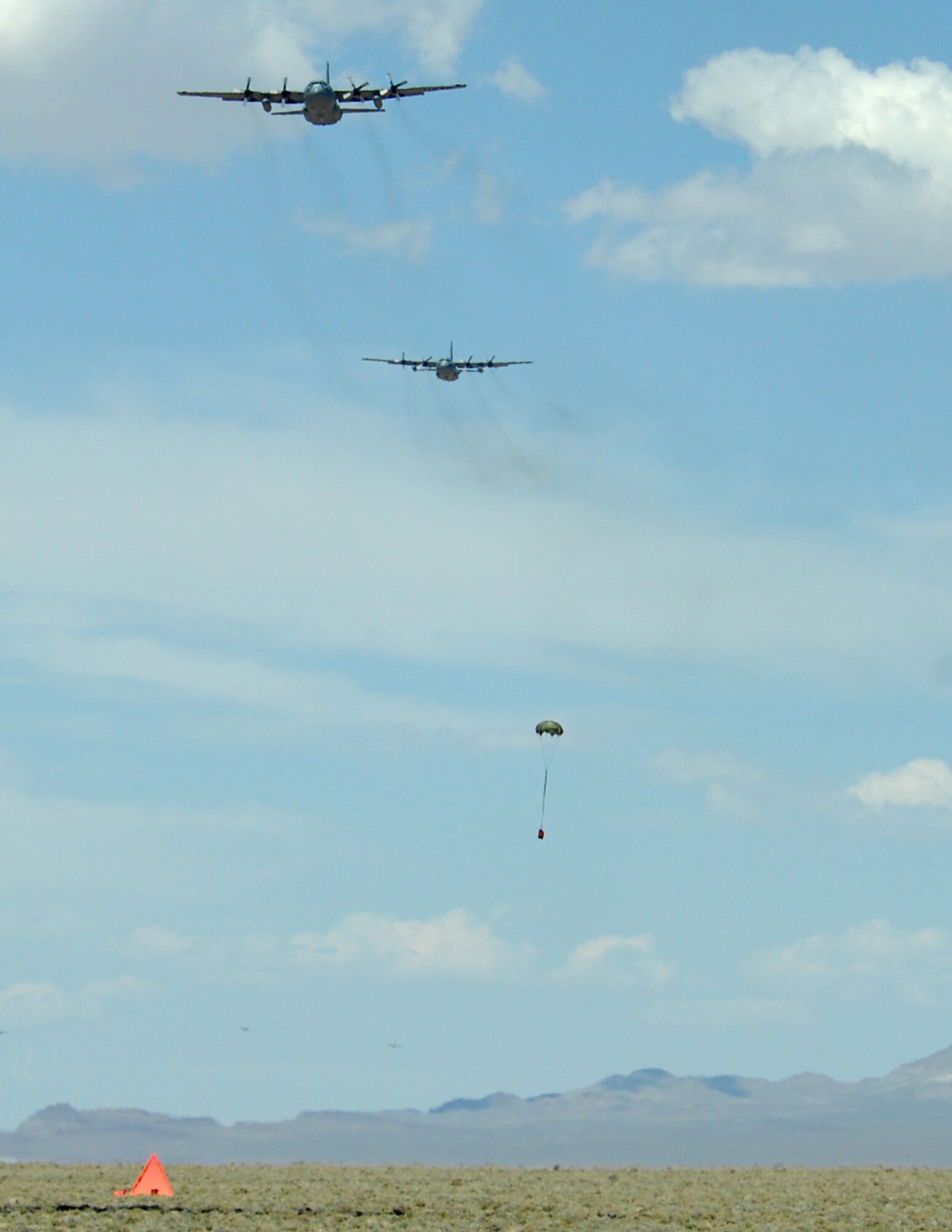 Two C-130 Hercules participating in the Mobility Air Forces Exercise make a pass over the drop zone May 20 at the Nevada Test and Training Range near Nellis Air Force Base.   Approximately 12 U.S. Air Force bases participate in the exercise at the U.S. Air Force Weapons School twice a year, testing the crew ability of C-17 Globemaster IIIs and C-130s to join together in formation at a specific time and location to drop a brigade-size force anywhere in the world.  (U.S. Air Force photo/Staff Sgt. Taylor Worley)


