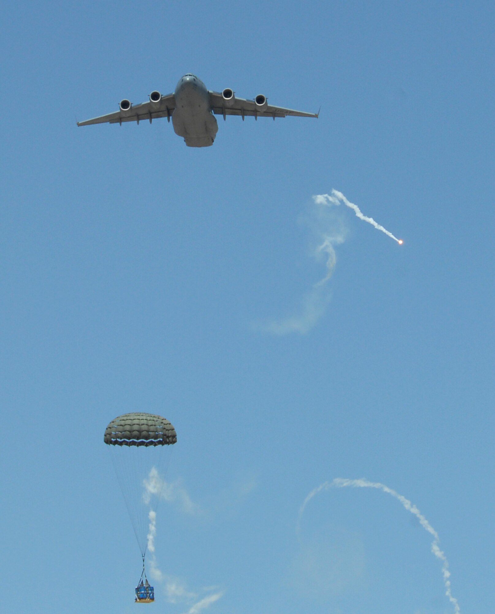 A C-17 Globemaster drops a container delivery system over the drop zone May 20 while participating in the Mobility Air Forces Exercise at Nellis Air Force Base, Nev.   (U.S. Air Force photo/Staff Sgt. Taylor Worley)

