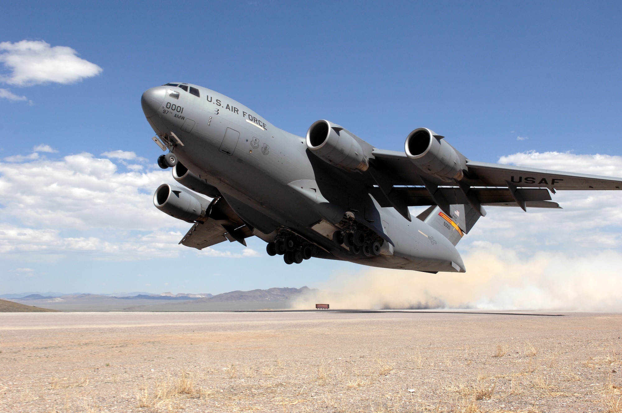 A C-17 Globemaster III assigned to the 97th Air Mobility Wing at Altus Air Force Base, Okla., takes off from the Tonopah runway May 20 near Nellis AFB, Nev., while participating in the Mobility Air Forces Exercise.  Approximately 12 U.S. Air Force bases participate in the exercise twice a year, testing the crew ability of C-17 Globemaster IIIs and C-130s to join together in formation at a specific time and location to drop a brigade-size force anywhere in the world. (U.S. Air Force photo/Airman 1st Class Brett Clashman)


