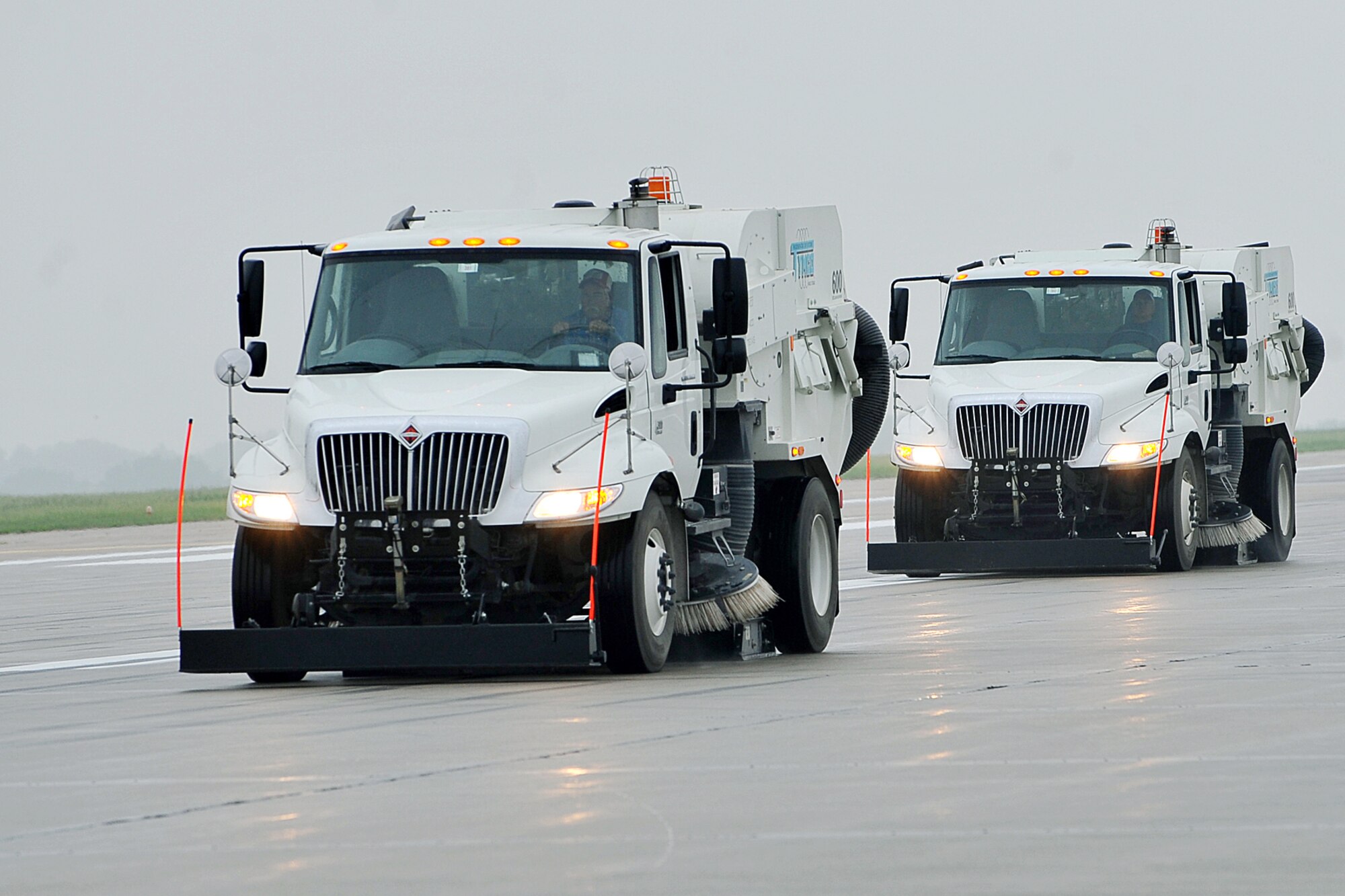 OFFUTT AIR FORCE BASE, Neb.,-- Two street sweepers clean Offutt's run way during a FOD walk here May 26. During the walk members of Team Offutt cleared the runway of debris and foreign objects helping ensure the safety of Offutt's aircraft and personnel. U.S. Air Force photo by Charles Haymond 