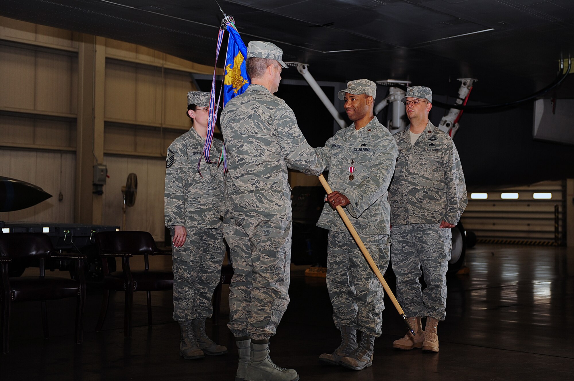Maj. Michael Edwards, outgoing 28th Maintenance Operations Squadron commander, hands the guidon to Col. Thomas Fitch, 28th Maintenance Group commander, during a change of command ceremony here, May 21. By handing the guidon off, Major Edwards relinquishes command of the 28 MOS. (U.S. Air Force photo/Airman 1st Class Joshua Seybert)
