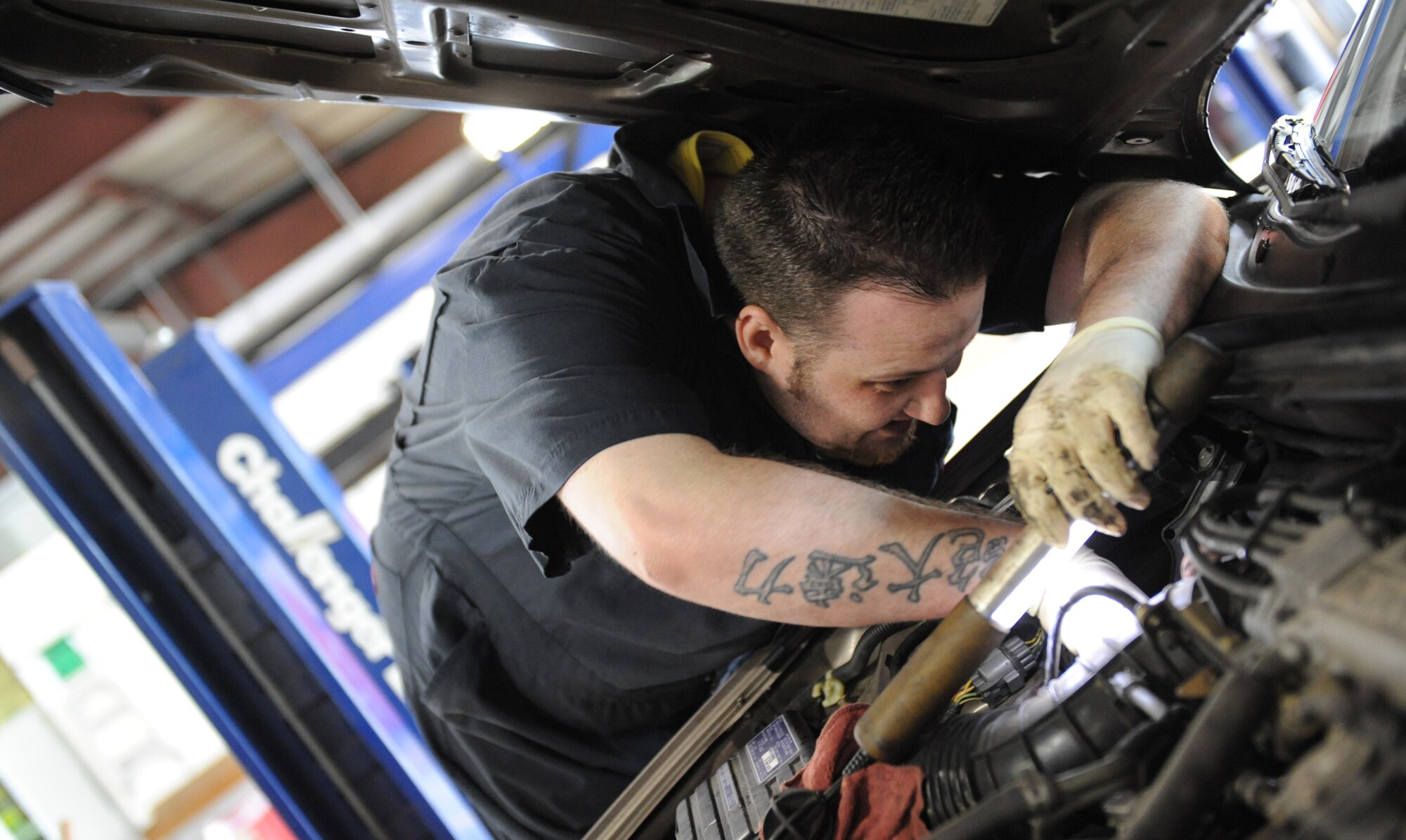 WHITEMAN AIR FORCE BASE, Mo. – Jacob Gooden, Auto Hobby Shop mechanic and husband of Staff Sgt. Angela Gooden, 509th Force Support Squadron, changes a hose on a Team Whiteman member’s car May 26. The Auto Hobby Shop is open Tuesday through Thursday from 8 a.m. to 5 p.m., Friday from 8 a.m. to 6 p.m. and 8 a.m. to 5 p.m. Saturday.  (U.S. Air Force photo/ Senior Airman Stephen Linch)