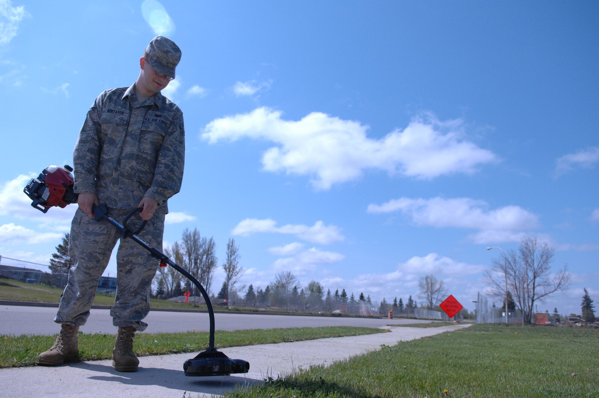 MINOT AIR FORCE BASE, N.D. -- Airman 1st Class Jesse Kertatos, 5th Civil Engineer Squadron engineer apprentice, edges his lawn in base housing here May 26. (U.S. Air Force photo by Staff Sgt. Angel Gallardo)