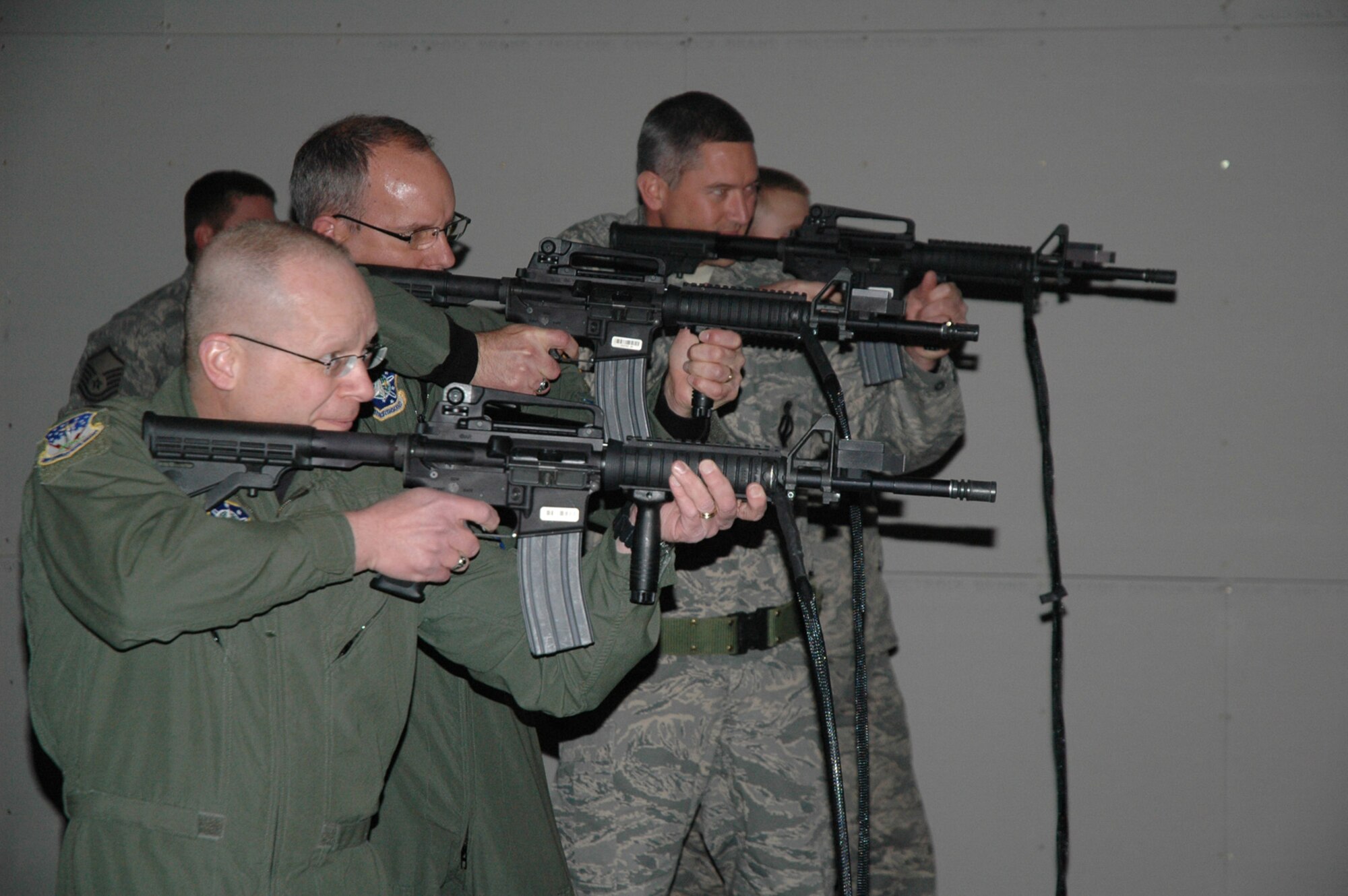 Cols. David Durgan, 341st Operations Group commander, Michael Fortney, 341st Missile Wing commander, and Paul Gydesen, 341st MW vice commander, send rounds down range during an Engagement Skills Trainer 2000 simulation April 14 in building 219. (U.S. Air Force photo/Senior Airman Dillon White)