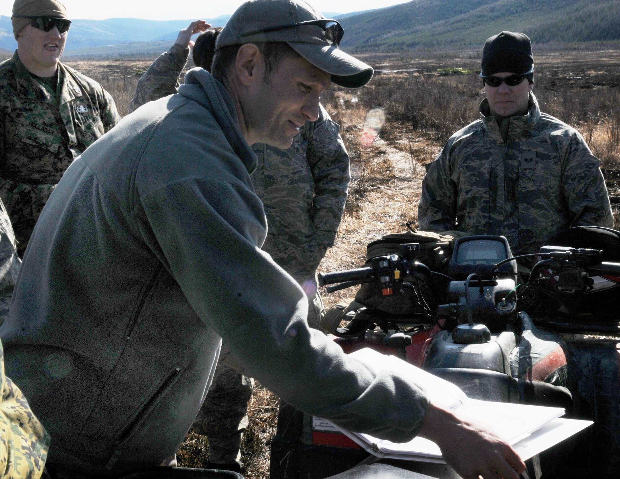 Senior Master Sgt. Albert Schneider gives a quick brief May 14 at the Pacific Alaskan Range Complex. The Airmen and Marines are clearing the range of live munitions after several Red Flag operations. Sergeant Schneider is with the 354th Civil Engineering Squadron Explosive Ordnance Flight at Eielson Air Force Base, Alaska. (U.S. Air Force photo/Airman 1st Class Laura Max) 
