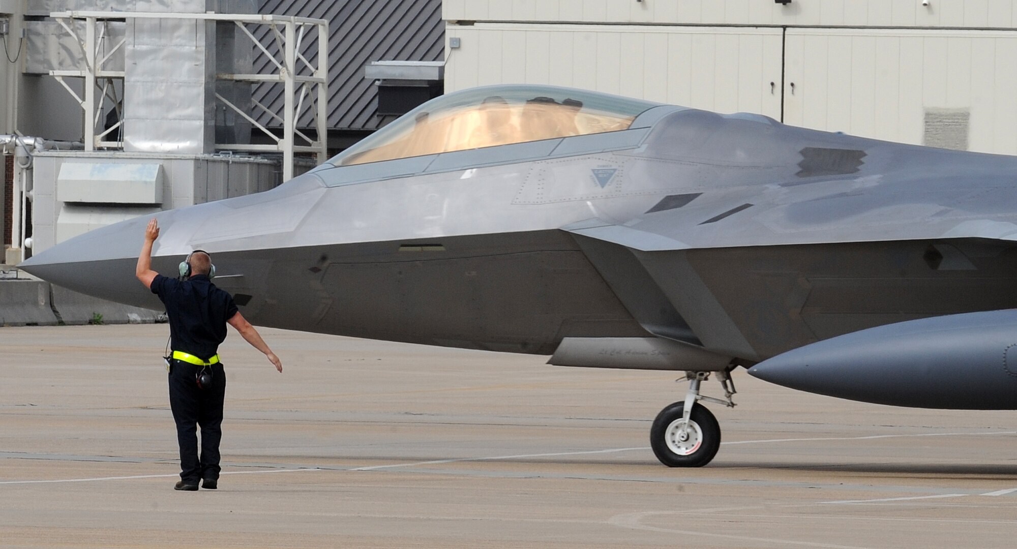 LANGLEY AIR FORCE BASE, Va. – A crew chief signals an F-22A Raptor from the 94th Fighter Squadron to taxi in preparation for departure to Kadena Air Base, Japan, May 26.  More than 280 Langley Airmen and 12 F-22A Raptors depart this week for their Air Expeditionary Force deployment, which demonstrates the continued U.S. commitment to fulfill its security responsibilities throughout the Western Pacific..  This is the first overseas deployment for the 94th Fighter Squadron since transitioning to the F-22.  (U.S. Air Force photo/Senior Airman Zachary Wolf)