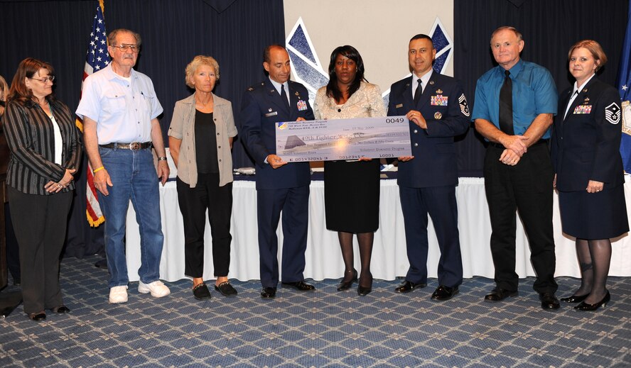 Members of Team Holloman are recognized at the annual Volunteer Recognition Ceremony at Holloman Air Force Base, N.M., May 19. Members of the Volunteer Resource Program present the 49th Fighter Wing with a check that represents the money base volunteers saved by giving their time. Base volunteers worked 30,605 hours, saving $229,522.50. (U.S. Air Force photo/Senior Airman Michael Means)