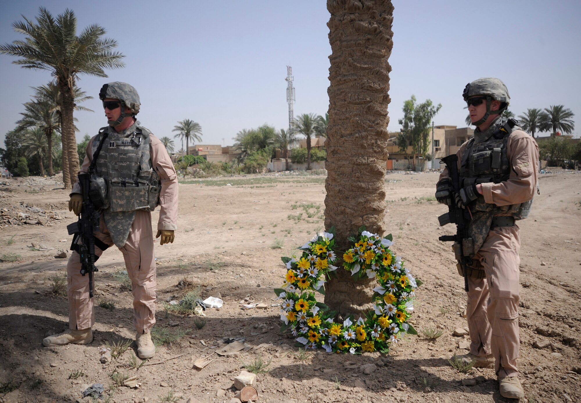 Capt. David Watts and Senior Airman Cole Magin stand beside a wreath placed as a memorial for Staff Sgt. John T. Self who was killed in action two years ago on this date when an improvised explosive device struck his vehicle May 14 in Iraq. Captain Watts and Airman Magin served with Sergeant Self and currently are deployed in support of Operation Iraqi Freedom. (U.S. Air Force photo/Staff Sgt. Shawn Weismiller) 
