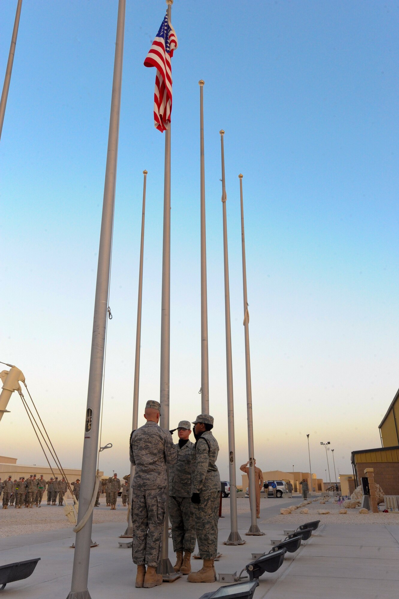 Members of the 379th Air Expeditionary Wing Honor Guard Team, lower the United States Flag during a Memorial Day Retreat ceremony, May 25, 2009, in an undisclosed location in Southwest Asia.  The retreat ended a day of remembrance for those who have died in service to the United States of America.  All members are deployed in support of Operations Iraqi and Enduring Freedom and Combined Joint Task Force - Horn of Africa.  (U.S. Air Force Photo by Staff Sgt. Joshua Garcia/released)