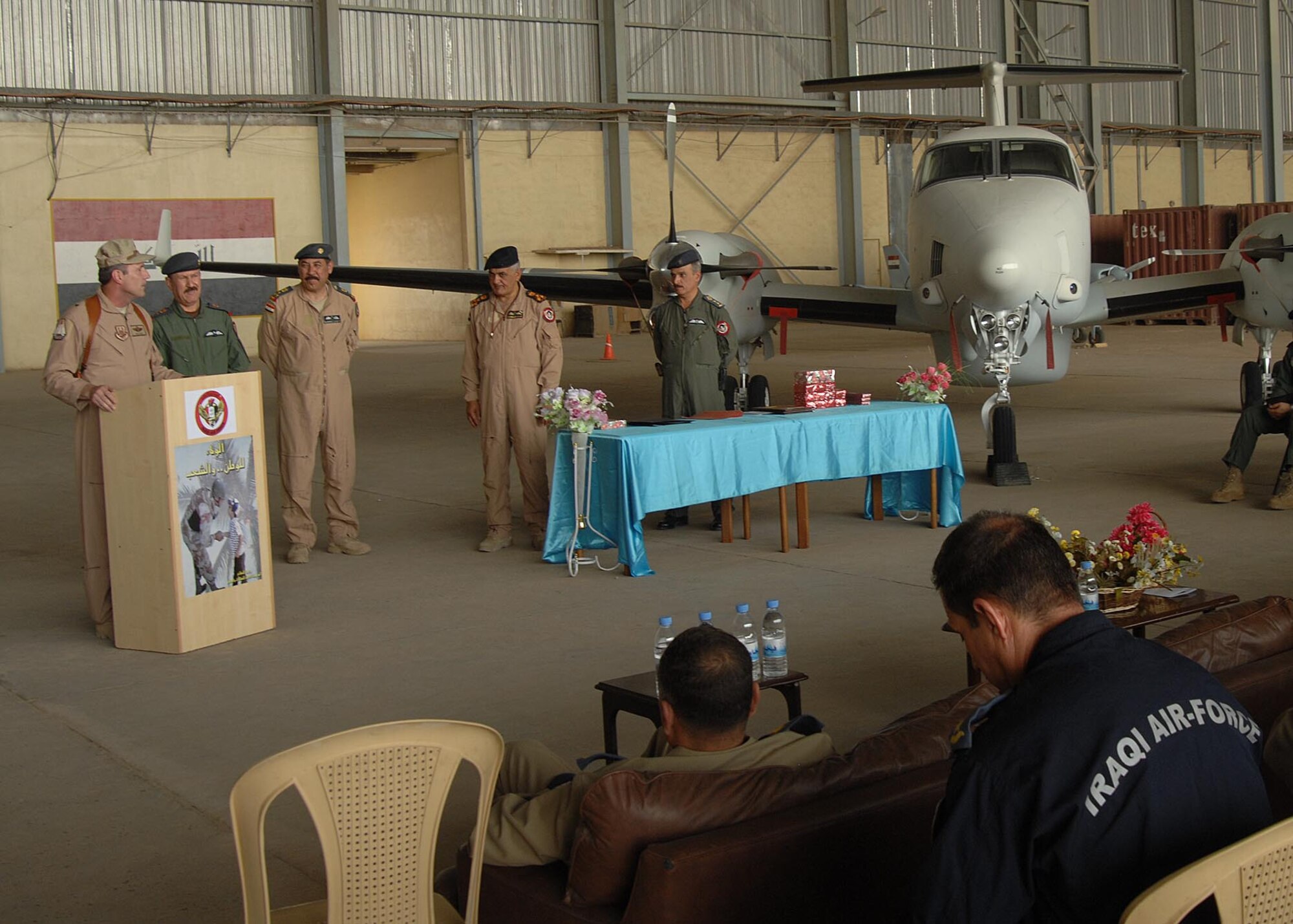 Brig. Gen. Robert Kane, 321st Air Expeditionary Wing and Coalition Air Force Training Team Commander, talks to the attendees of the Iraqi King Air graduation at New Al Muthana Air Base May 17, while the Iraqi Air Force Commander, Staff Lieutenant General Anwar, looks on. (U.S. Air Force photo by Staff Sgt. Tim Beckham)
