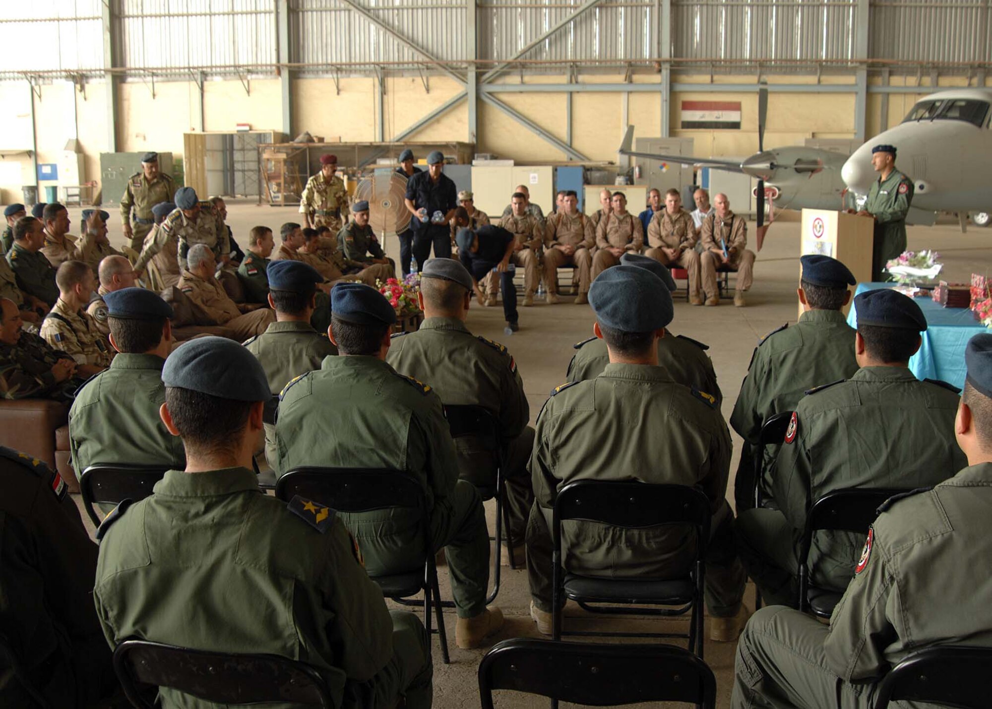 Members of the first Iraqi intelligence, surveillance and reconnaissance class wait for their names to be called during their graduation ceremony at New Al Muthana Air Base May 17. The Iraqi King Air program, headed up by U.S. Air Force and Navy aircrew instructors, graduated four Iraqi pilots, seven co-pilots and five mission sensor operators after a year of training. (U.S. Air Force photo by Staff Sgt. Tim Beckham)