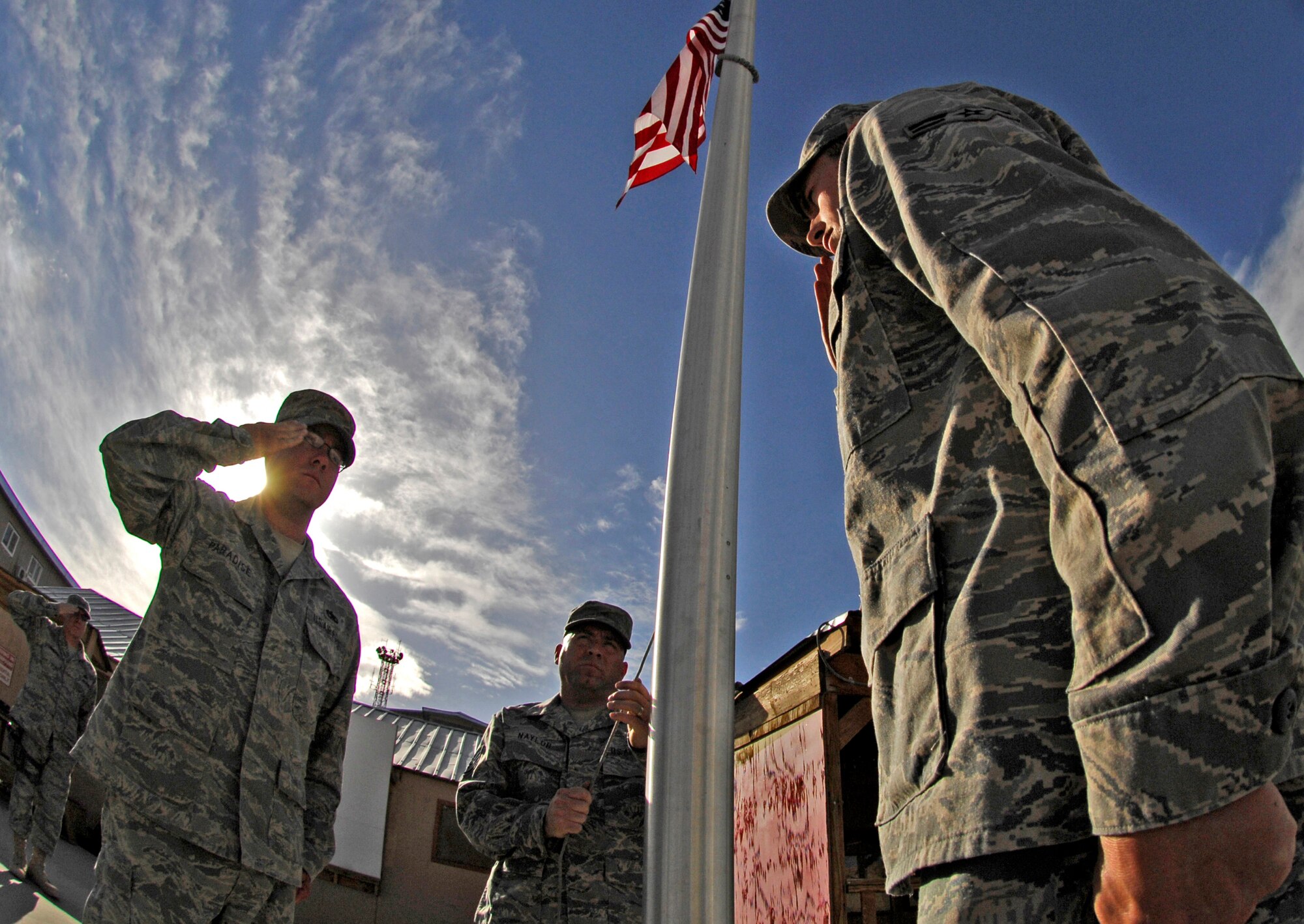 BAGRAM AIR FIELD, Afghanistan -- Staff Sgt. Brandon Paradise, Staff Sgt. Christopher Naylor and Airman 1st Class James Loftus from the 455th Expeditionary Civil Engineer Squadron force protection participate in a Memorial Day ceremony at Camp Cunningham May 25. A team of seven Air Force honor guardsmen flew and folded nearly 50 flags over a three-hour period on behalf of the 455th Air Expeditionary Wing. The flags and a certificate will be sent home to friends and family of servicemembers in honor of the national holiday. (Air Force/Staff Sgt. Jason Lake) 