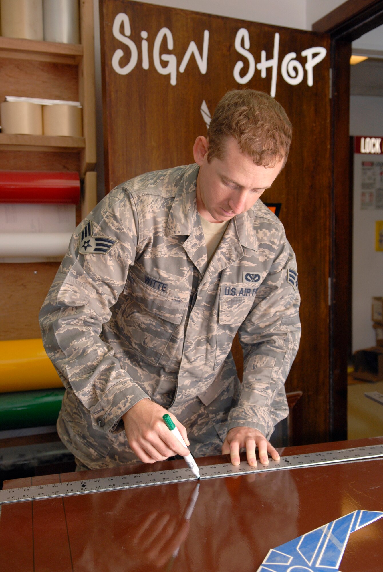 Senior Airman Geoffrey Witte, a 379th Expeditionary Civil Engineer structural journeyman, marks off dimensions on sheet metal for a new sign for the Wing Operations Center, May 21, 2009, at an undisclosed location in Southwest Asia.  The sign shop uses an array of materials to create building, road, and other signs used throughout the base.  Airman Witte hails from Anadarko, Okla. and is deployed from Vandenberg Air Force Base, Calif. in support of Operations Iraqi and Enduring Freedom and Combined Joint Task Force - Horn of Africa.  (U.S. Air Force photo/Senior Airman Andrew Satran/released)