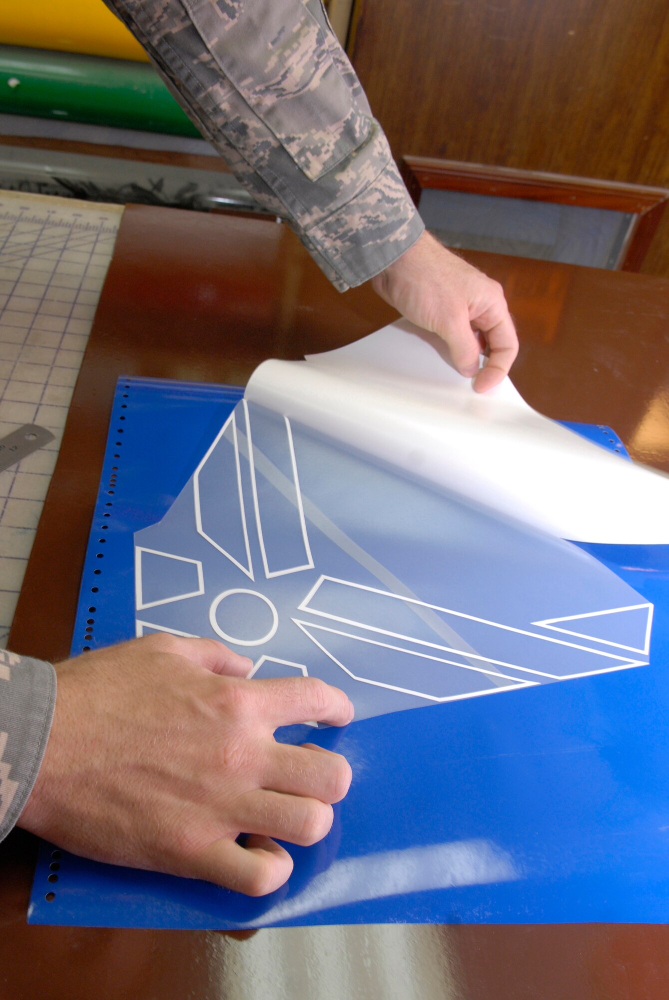 Senior Airman Geoffrey Witte, 379th Expeditionary Civil Engineer Structural Journeyman, prepares to cut out the Air Force symbol from vinyl for a new Wing Operations Center sign, May 21, 2009, at an undisclosed location in Southwest Asia.  The sign shop uses an array of materials to create building, road, and other signs used throughout the base.  Airman Witte hails from Anadarko, Okla. and is deployed from Vandenberg Air Force Base, Calif. in support of Operations Iraqi and Enduring Freedom and Combined Joint Task Force - Horn of Africa.  (U.S. Air Force photo/Senior Airman Andrew Satran/released) 