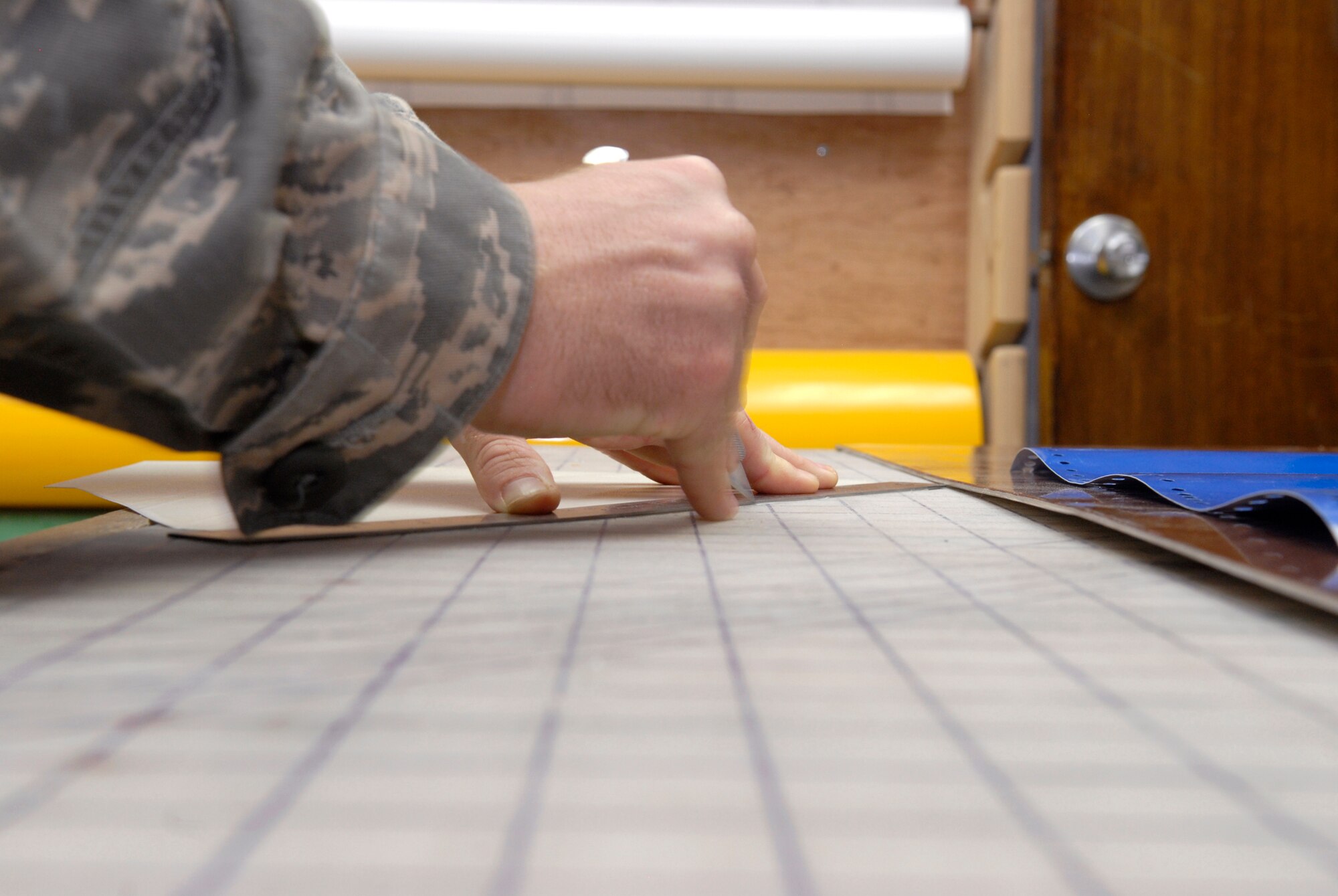 Senior Airman Geoffrey Witte, 379th Expeditionary Civil Engineer Structural Journeyman, cuts out a template of the Air Force symbol which he will use to cut the symbol from vinyl for a new Wing Operations Center sign, May 21, 2009, at an undisclosed location in Southwest Asia.  The sign shop uses an array of materials to create building, road, and other signs used throughout the base.  Airman Witte hails from Anadarko, Okla. and is deployed from Vandenberg Air Force Base, Calif. in support of Operations Iraqi and Enduring Freedom and Combined Joint Task Force - Horn of Africa.  (U.S. Air Force photo/Senior Airman Andrew Satran/released) 