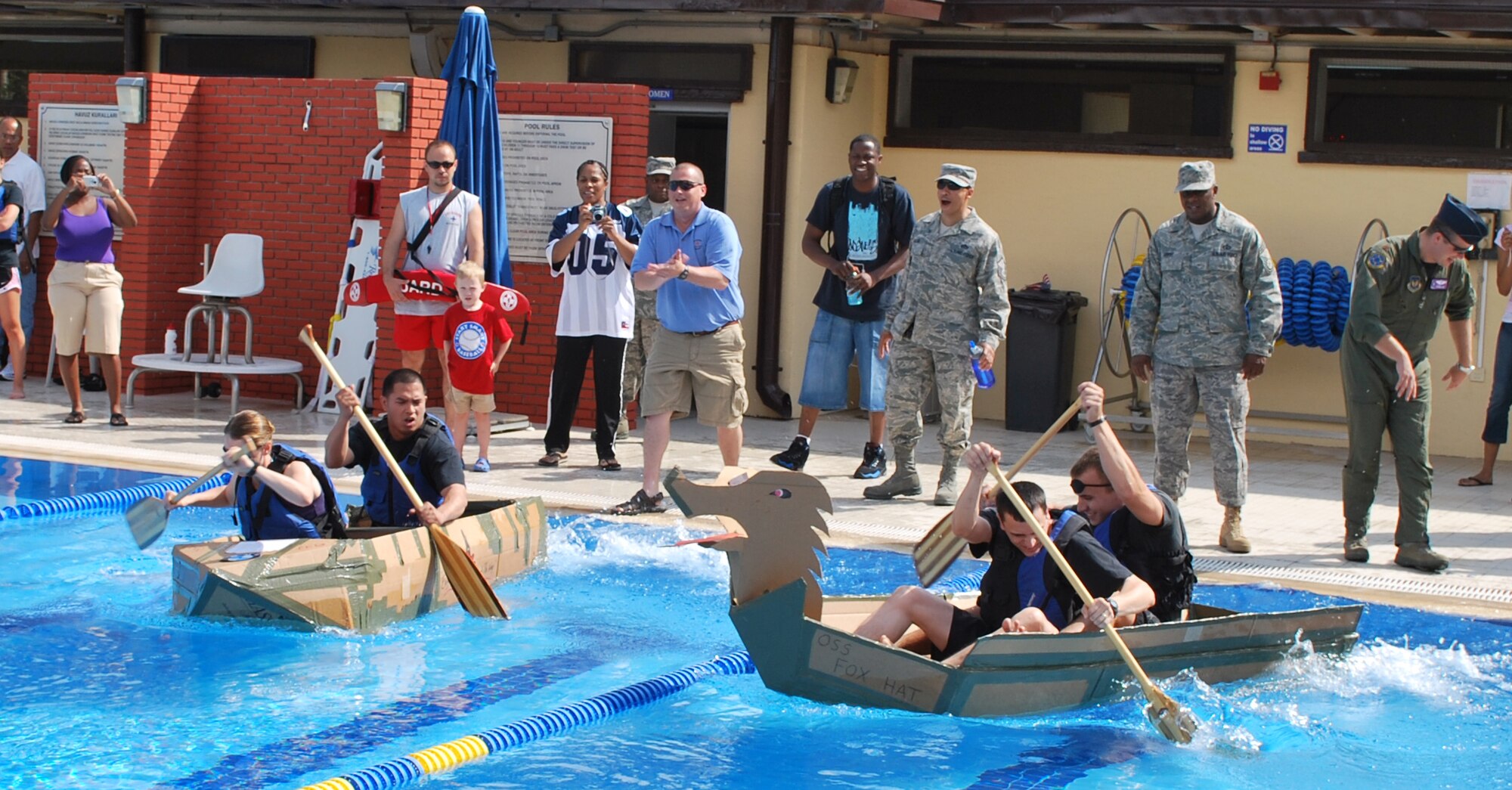 The 39th Operations Squadron team and the 39th Civil Engineer Squadron team frantically paddle their boats from the starting line of a race during the championship heat of the Incirlik build-a-boat competition, Friday, May 22, 2009. The 39 CES team finished in first place and was awarded a $100 gift certificate to be spent at a services location on base. Teams were given four pieces of cardboard and two rolls of duct tape to build the best sea-worthy boat possible before the event. Five teams competed and prizes were awarded for fasted boat, best decoration and first boat to sink. (photo/Staff Sgt. Martin Wallace)