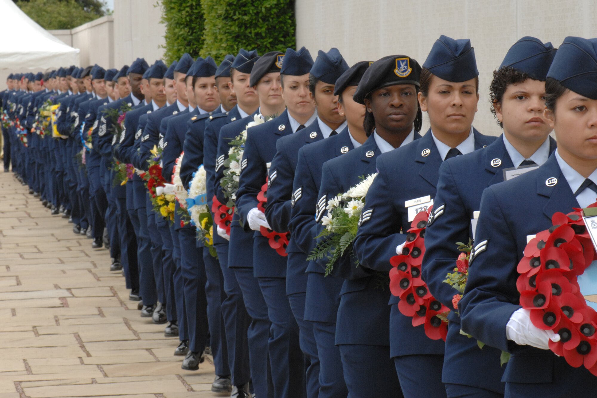 RAF MLDENHALL, England – Dozens of Airmen carry wreaths donated from various organizations to lay at the Wall of the Lost as part of the Memorial Day event at Madingley Memorial Cemetery, May 25, 2009.  The event is held annually and includes full military honors.  (U.S. Air Force file photo)