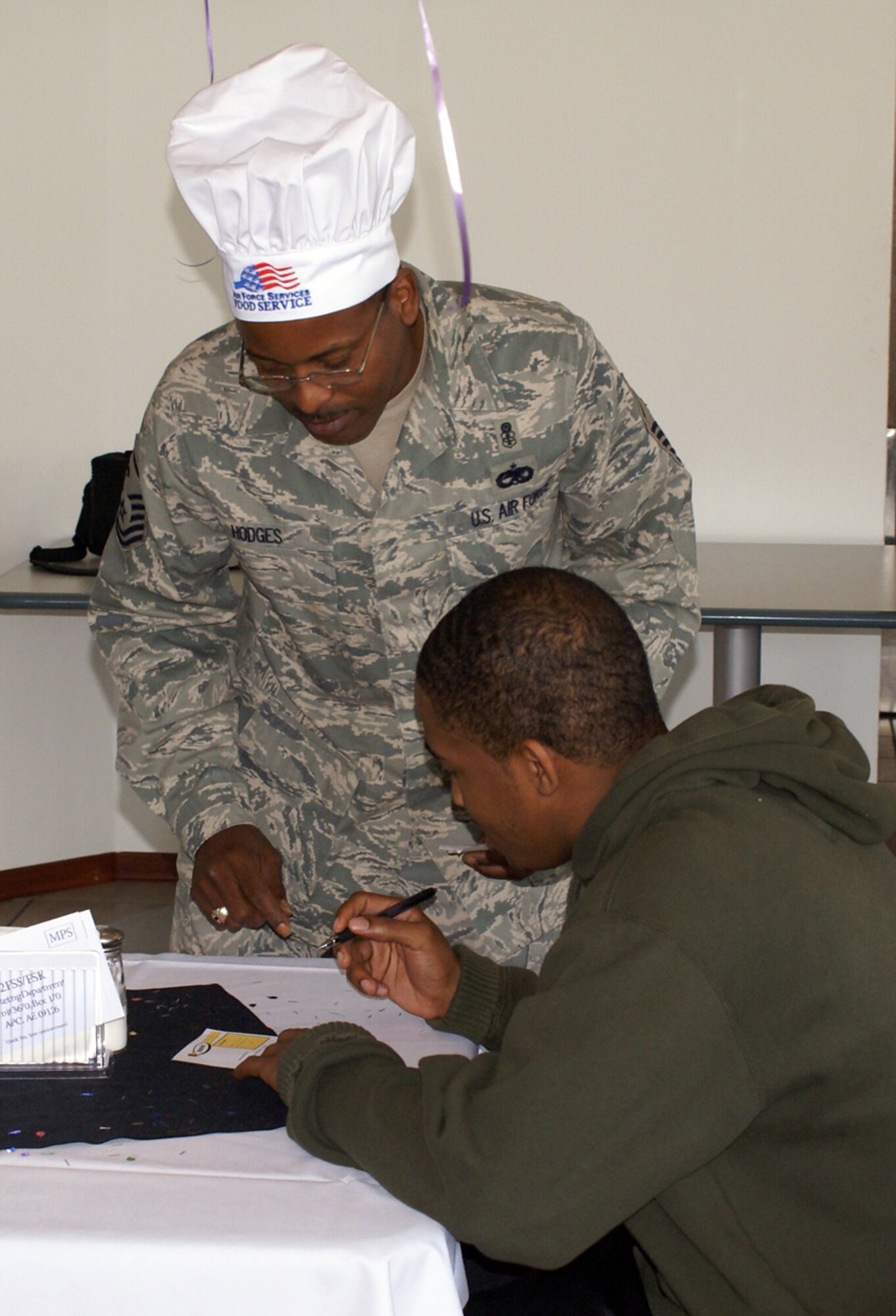 SPANGDAHLEM AIR BASE, Germany -- Master Sgt. Alfred Hodges, 726th Air Mobility Squadron first sergeant, talks to an Airmen during a birthday meal at the Mosel Dining Facility May 19, 2009. (U.S. Air Force photo by Senior Master Sgt. Dennis Wingett)