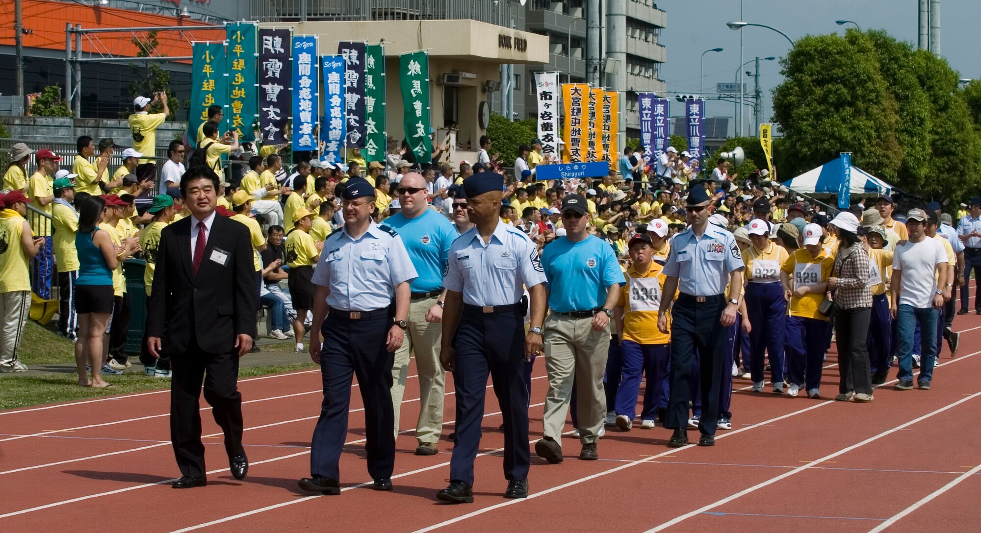 YOKOTA AIR BASE, Japan -- (Left to right) Ikuo Kato, Fussa City mayor, Col. Frank Eppich, 374th Airlift Wing vice commander, and Chief Master Sgt. Linus Jordan, 374th AW command chief master sergeant, lead the Parade of Hope May 23 at the opening ceremonies of the 30th Annual Kanto Plain Special Olympics at Yokota's Bonk Field. More than 100 athletes from eight local schools competed in events ranging from the standing long jump and 50-meter dash to bowling and swimming. More than 300 volunteers from U.S. military installations and members of the Japanese Self Defense Forces also took part in the event. (U.S. Air Force photo/Master Sgt. Matt Summers)